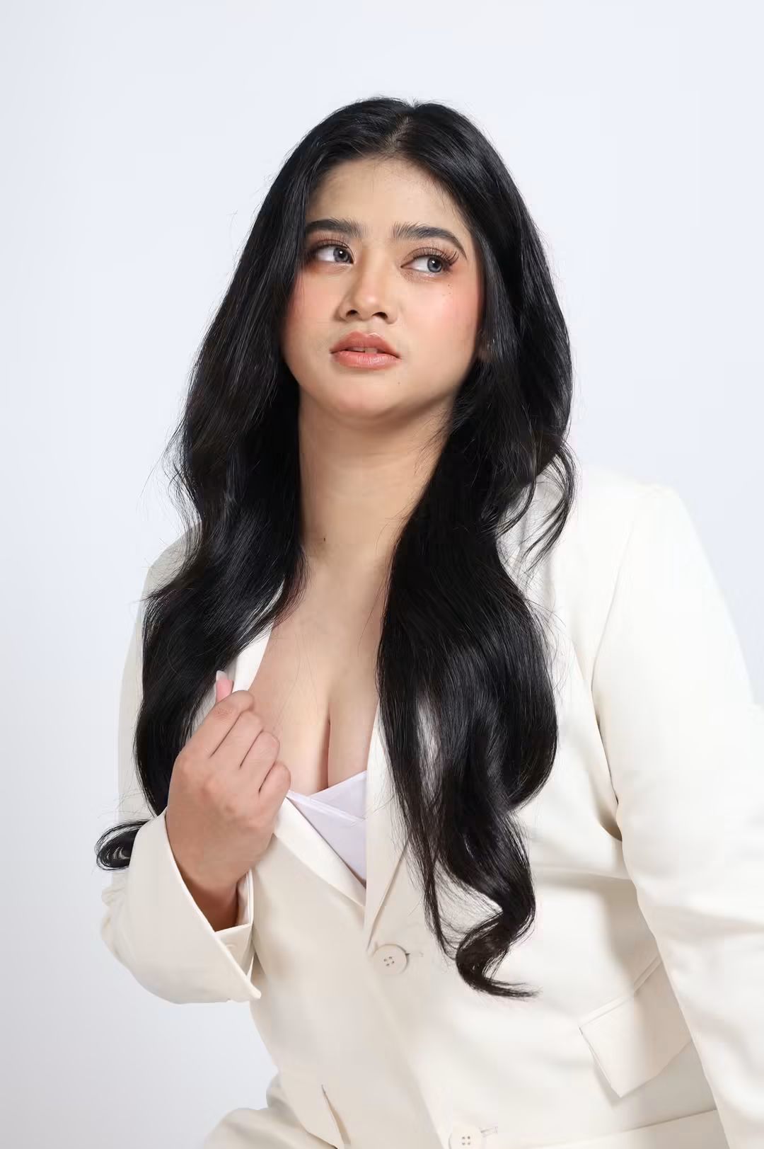 Tala looking away in a white blazer